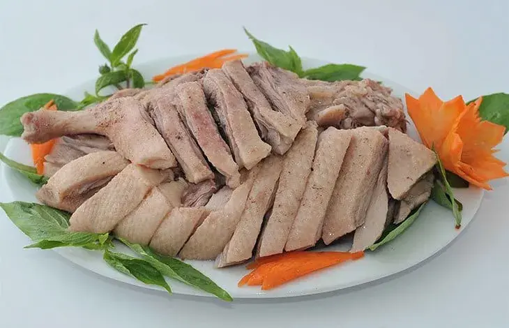 Použitá kachní maso na bílém talíři s ozdobami.