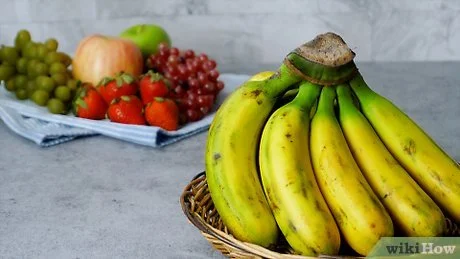 Žluté banány v košíku na šedém povrchu bez řezu.