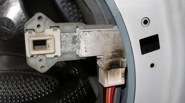 Znečištěný elektrický konektor senzoru uvnitř pračky Indesit.