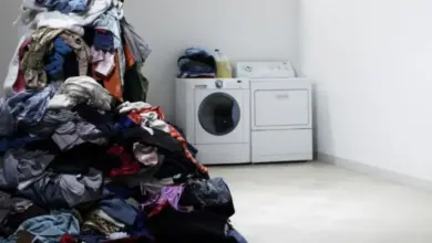 Hromada špinavého prádla vedle pračky v koupelně