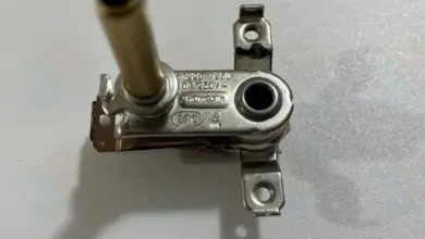 Detail termostatu pro elektrickou troubu s viditelnými označeními.