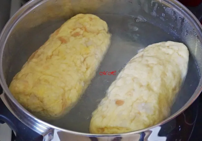 Dva knedlíky se vaří ve vodě v hrnci.