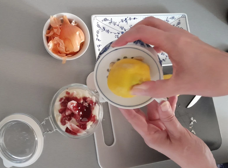 Ruka vymačká citron do misky s medem pro recept.