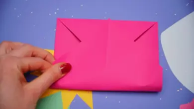 Ruční skládání růžové papírové obálky z formátu A4.