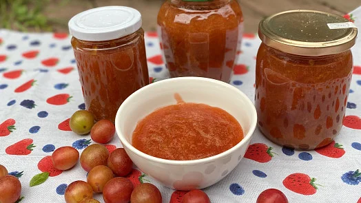 Sklenice domácí marmelády s čerstvými ovocem na ubrusu.