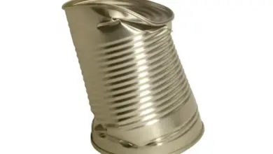 Nafouklá plechovka s výrazným poškozením stěny.