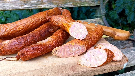 Domácí vepřová klobása nakrájená na plátky s viditelným masem.