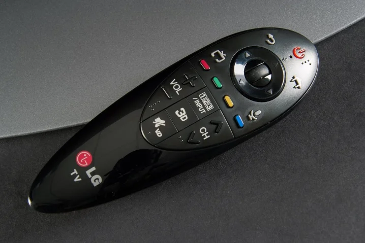 Černý dálkový ovladač televizoru značky LG na tmavém povrchu.